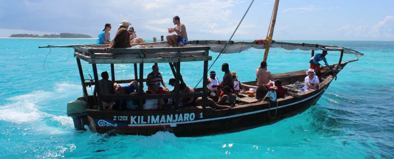 volunteers in Africa enjoying a boat ride in the turquoise blue waters