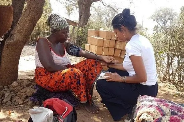 Medical and healthcare intern attending to local woman in Africa