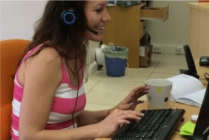 Volunteer in an office workspace, seated at a desk and wearing a headset
