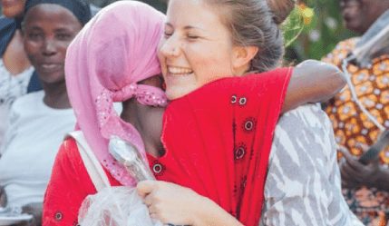 volunteer hugging a local in Africa