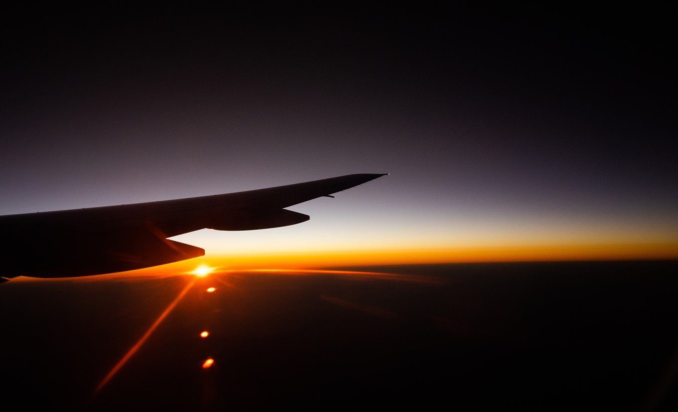 View of sunrise from inside airplane on the way to volunteer project destination.