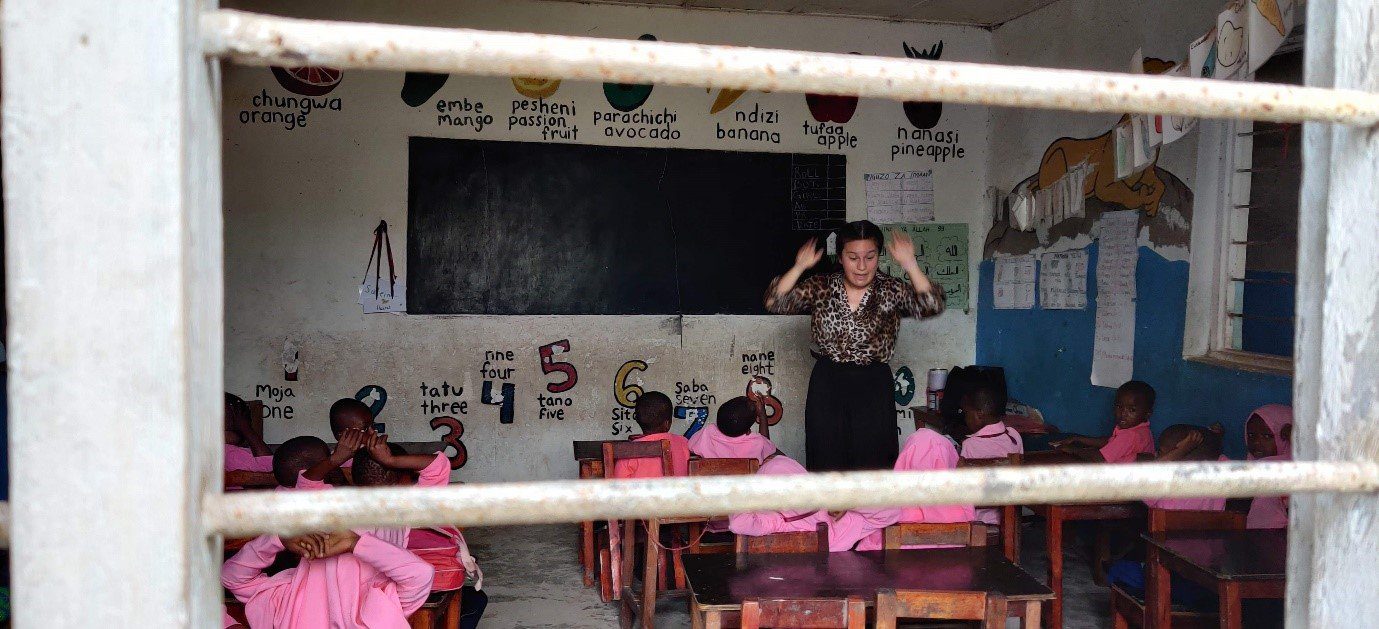 Volunteer teacher educating young children at a school in Zanzibar.