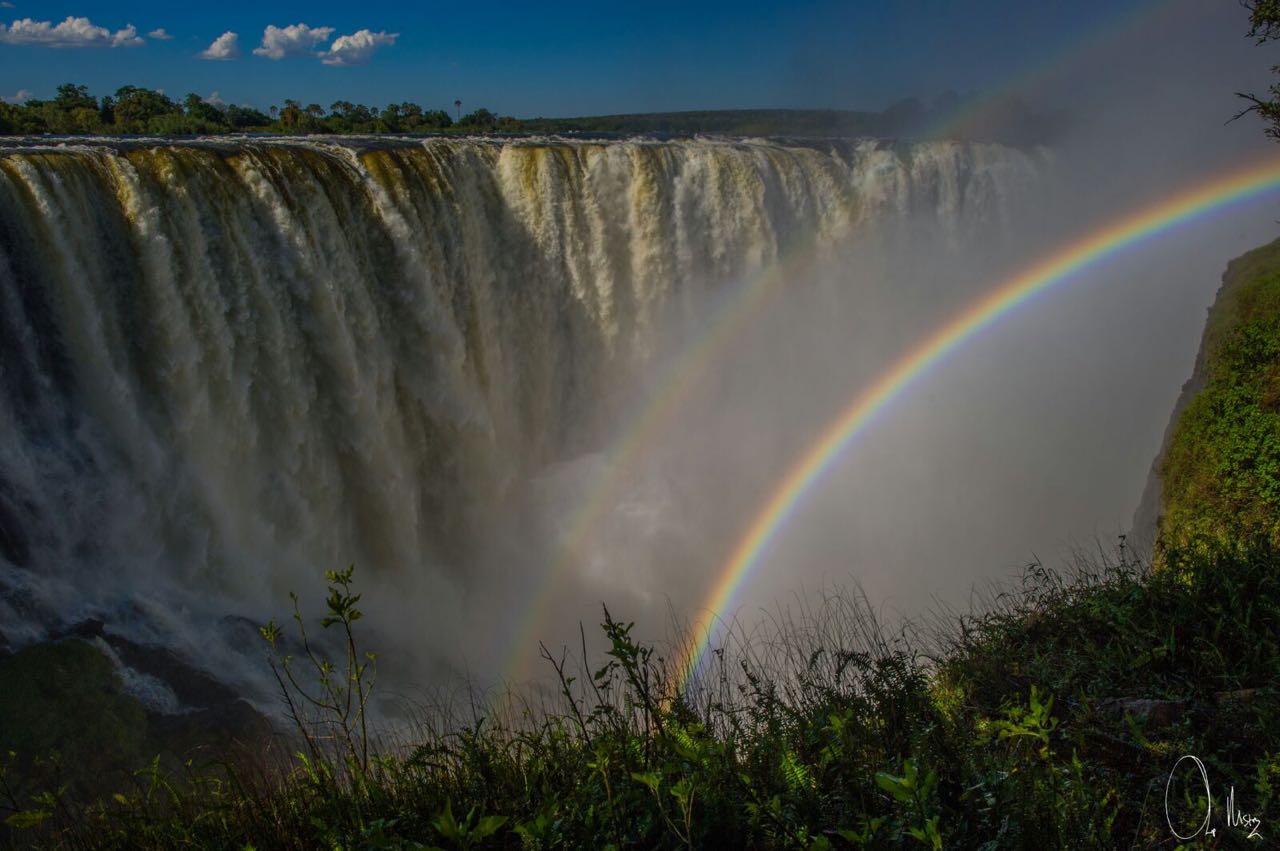 Rainbow shining over Victoria Falls in Zambia.