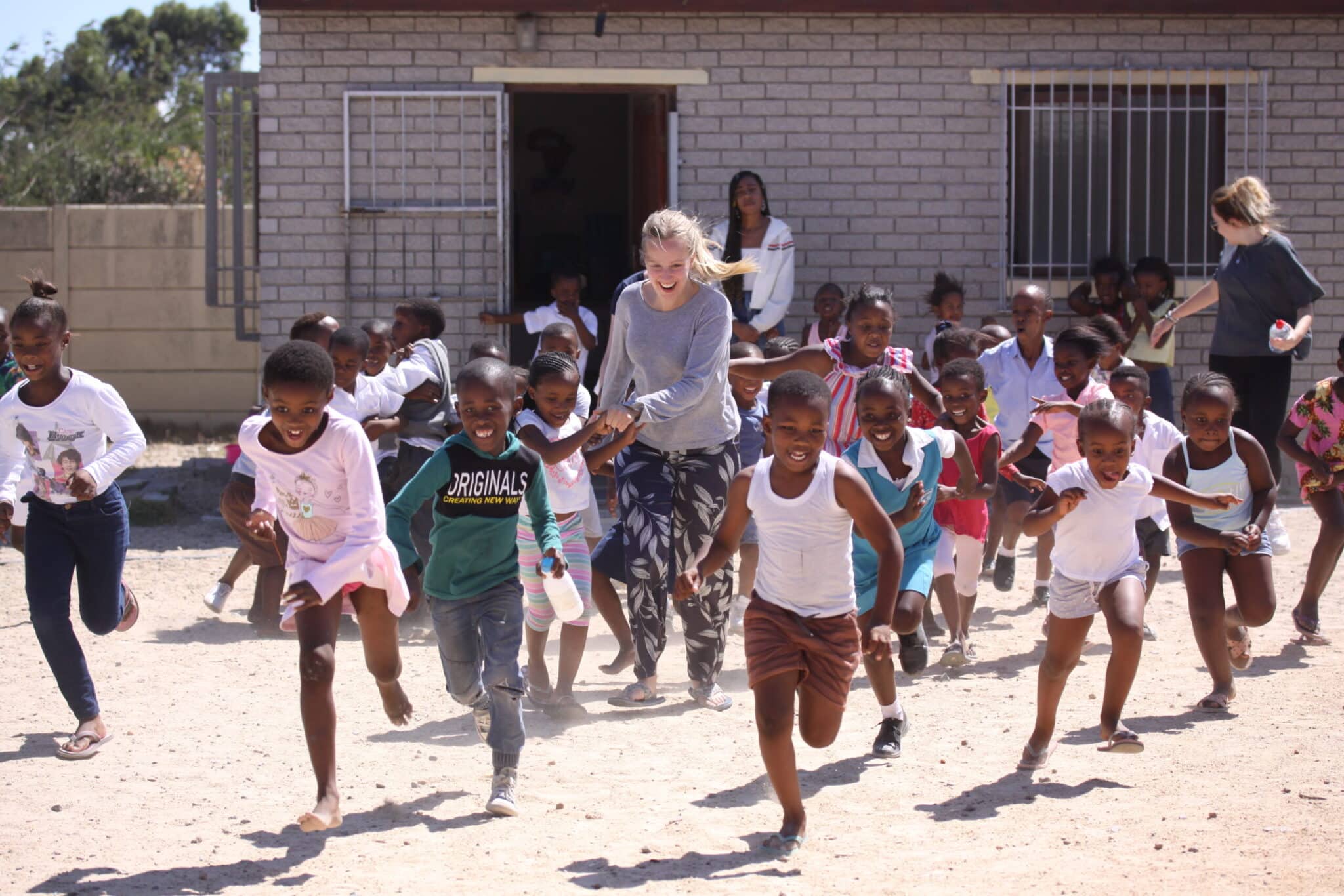 volunteer in cape town with children playing a game outside