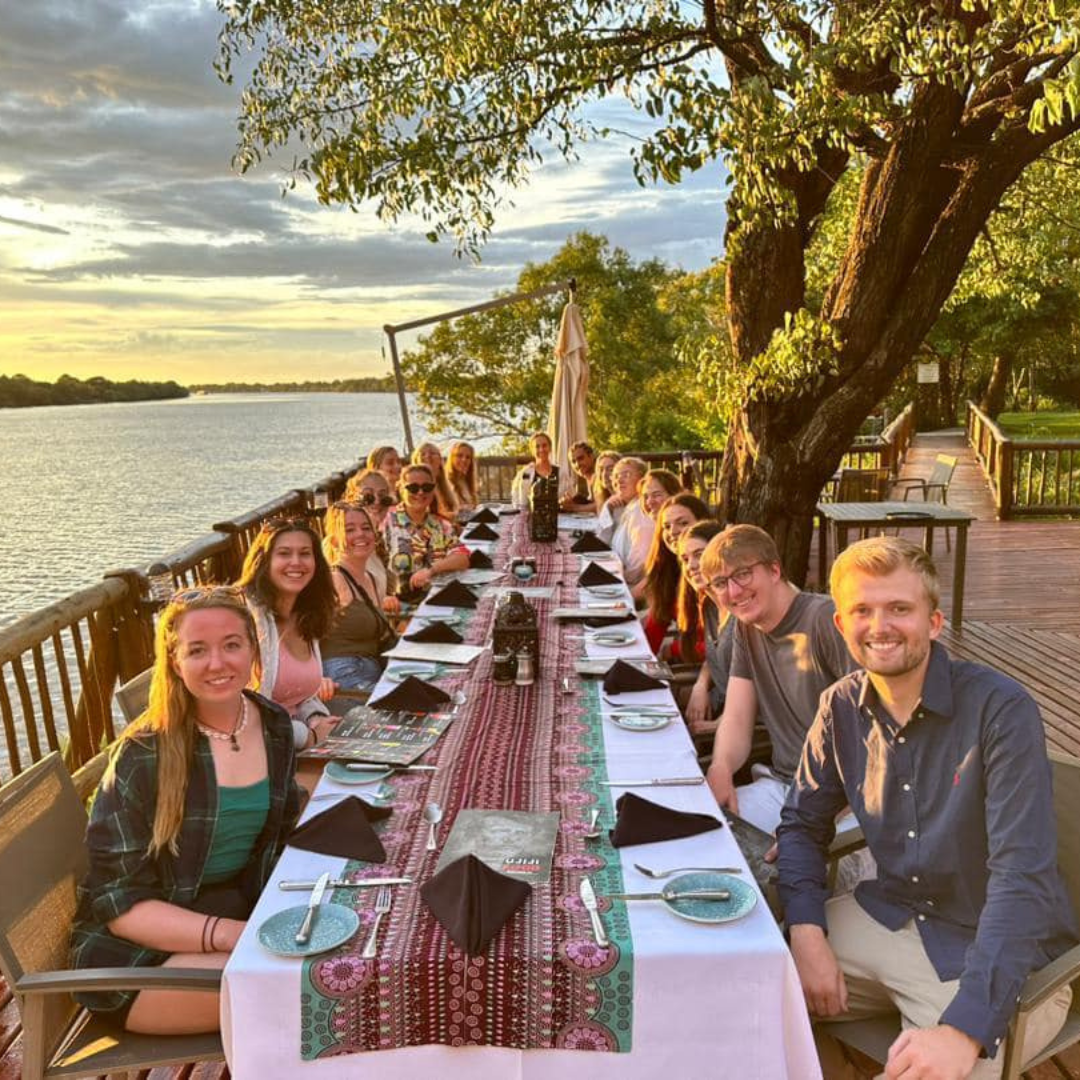 volunteers watching the sunset over the zambezi river