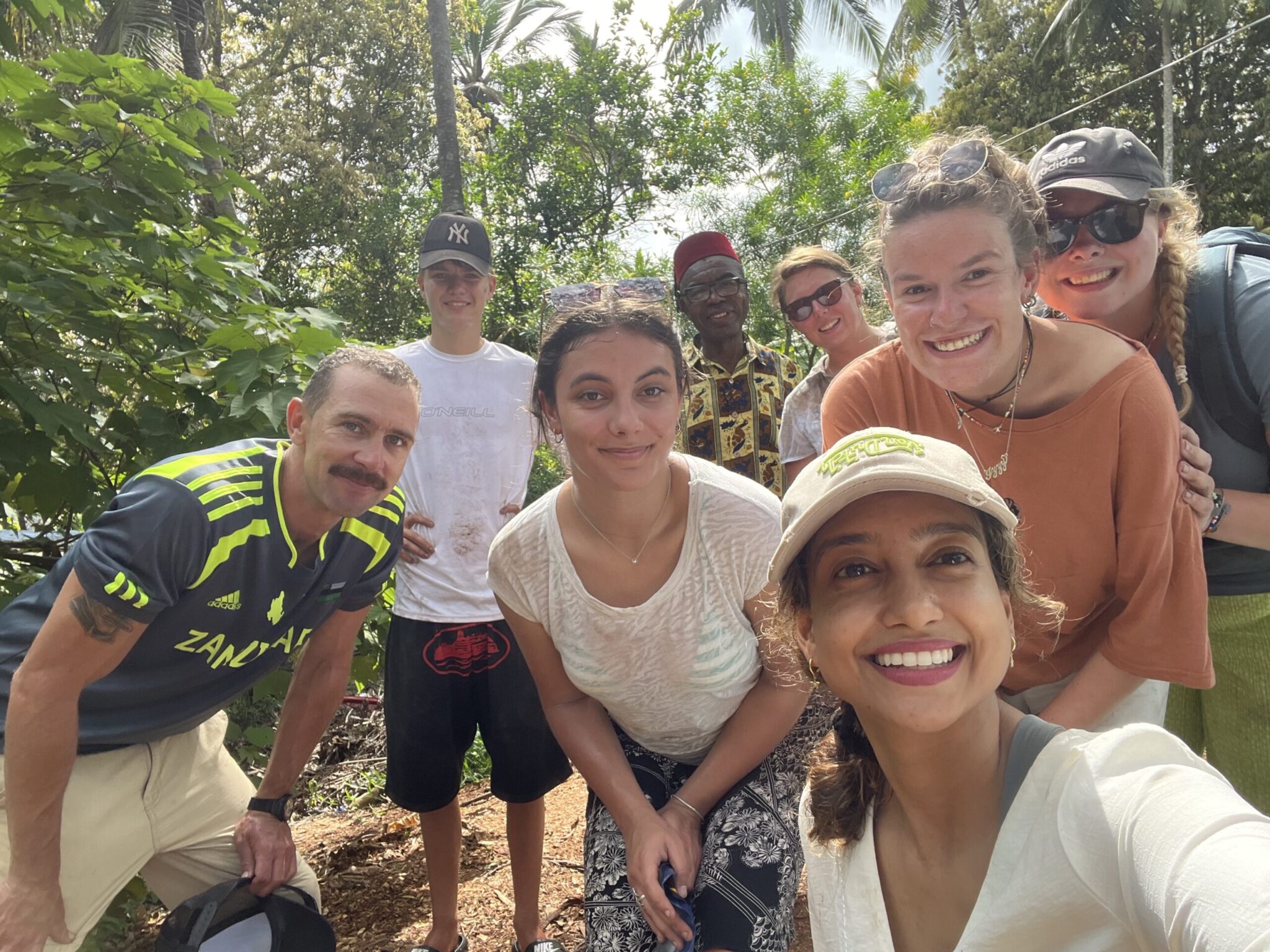 While exploring a jungle area, volunteers gather for a group selfie