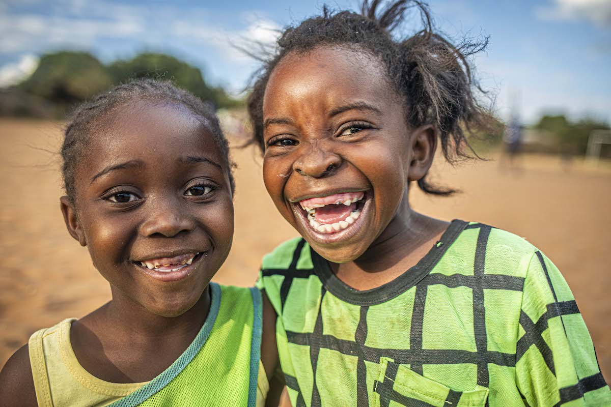Two happy children are smiling together while posing for a photo together in Livingstone, Zambia.