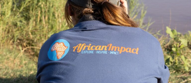 African Impact logo printed at the back of a volunteer's shirt