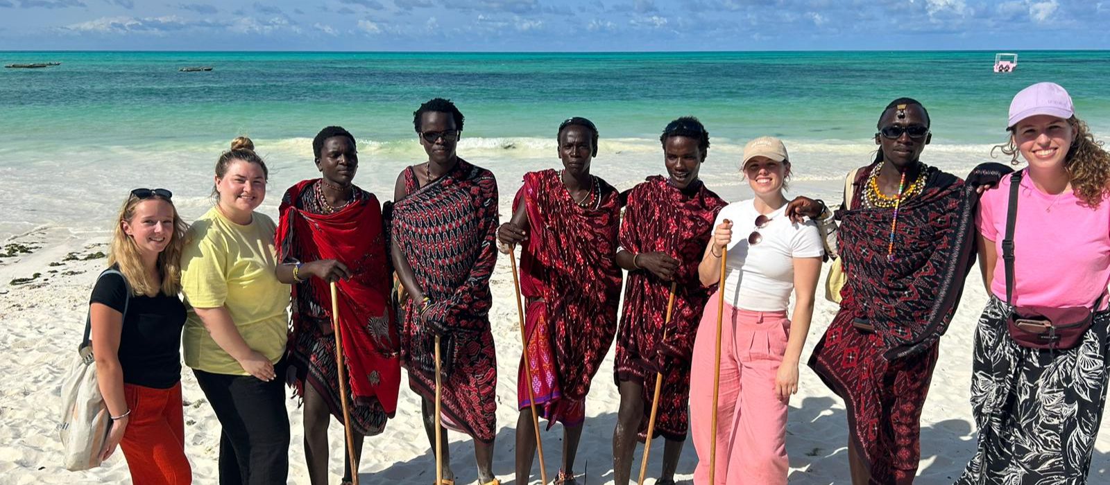 Volunteers and locals in Africa posing for a photo on the beach
