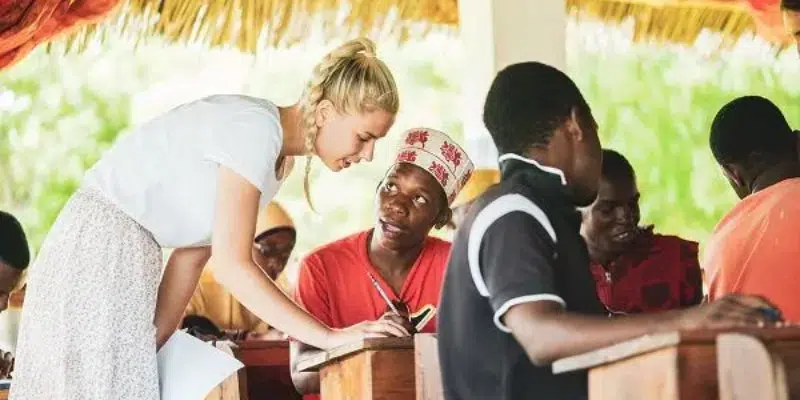 A woman assisting a student with his homework