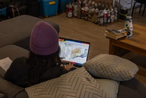 a woman sitting on a couch while using her laptop