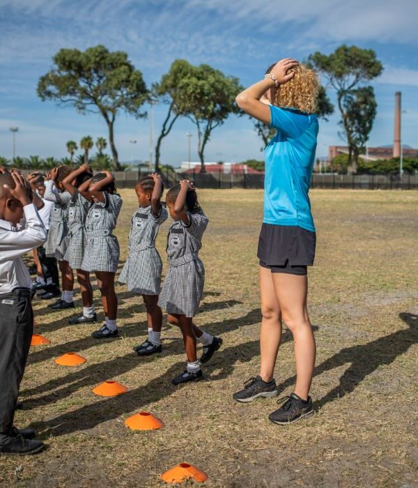 Instructor leading a group of children in a structured physical activity session