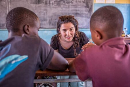 a volunteer talking to two boys