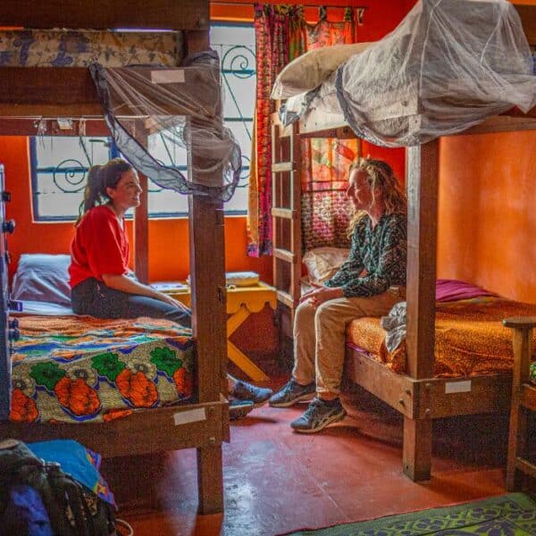 Two women chatting in a cozy, colorful bunk-bed room