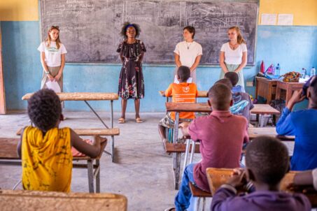 Teachers and students in a classroom setting, discussing a lesson together