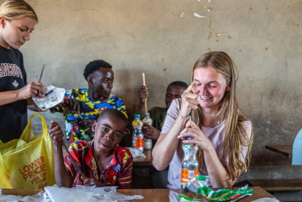 Volunteers and young children holding plastic bottles