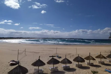 A sunny beach scene featuring umbrellas.