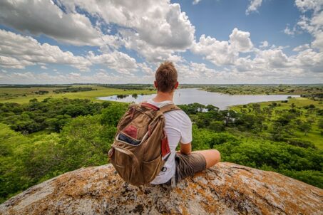 A man sitting on top of a mountain, enjoying the beautiful view
