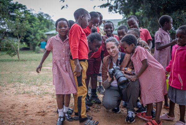 a volunteer showing a photo to young kids on her camera