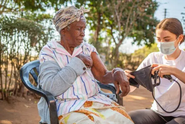 healthcare worker checking an elderly's blood pressure