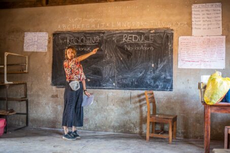 A volunteer teacher pointing at something on the board