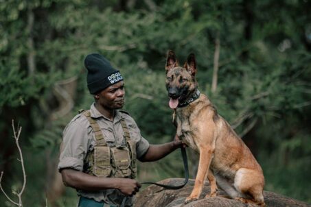 A man standing with a dog beside him